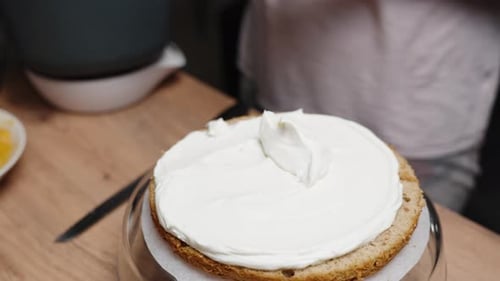 Woman Frosting Cake on a Rotating Stand