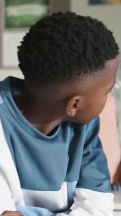 Vertical video: Turning student glancing right at school, hearing peer speaking, wearing blue top
