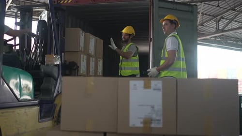 Blue collar workers are working at warehouse.