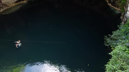 Two People Swimming in an Underground Cave Cenote