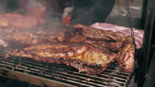 Gegrillte Schweinerippchen auf dem Flaming Grill Nahaufnahme des Öffnens des Grills