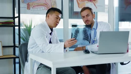 Two Multiethnic Professional Therapist Doctors Communicating in Office Discussing Coronavirus