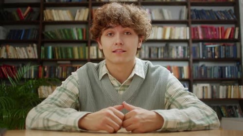 Young Adult Speaking in Front of Bookshelf