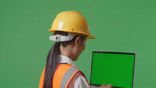 Close Up Back View Of Asian Female Engineer Working On A Green Screen Laptop In The Green Screen