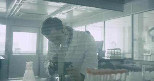 Man Analyzing Sample Using Microscope in Bright Lab
