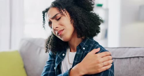Woman Massaging Sore Shoulder in Home
