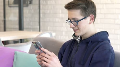 Teen Using a Mobile Phone Indoors During the Day