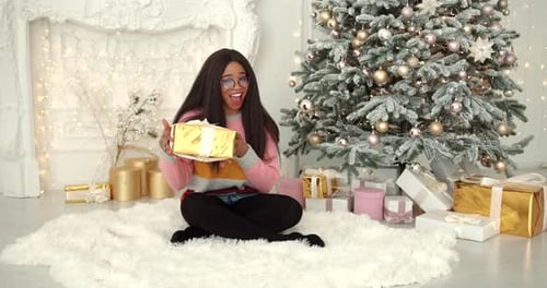 Woman Holding Christmas Gift in Festive Home Setting