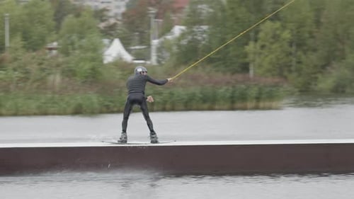 Wakeboard Sportsman Sliding on Slider at Wake Park