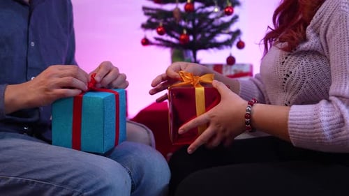 Couple Opening Christmas Gifts Together at Home
