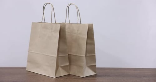 Three Paper Shopping Bags on Tabletop Surface