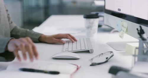 Hands, typing and writing in a notebook with a keyboard for work, business and planning a strategy