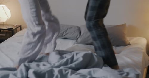 Happy Couple Dancing on Bed in Bedroom