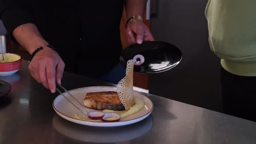 Chef Finishing Dish with Red Onion and Tweezers
