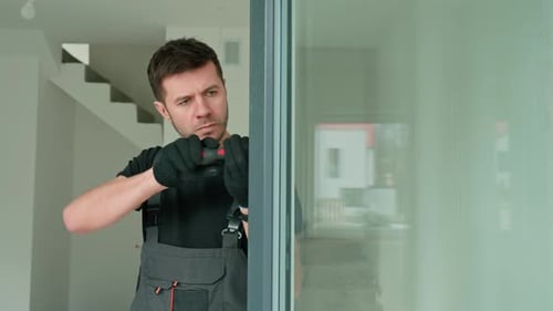 Man Adjusting Sliding Glass Door Frame with Screwdriver