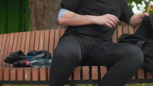 La personne organise son équipement en silence. L'individu fixe son casque sur un banc relaxant, le voyageur concentré se prépare