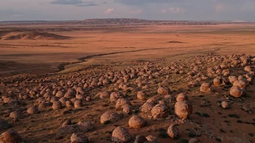 Experience the Stunning View of Unique Rock Formations Amidst the Expansive Desert Landscape