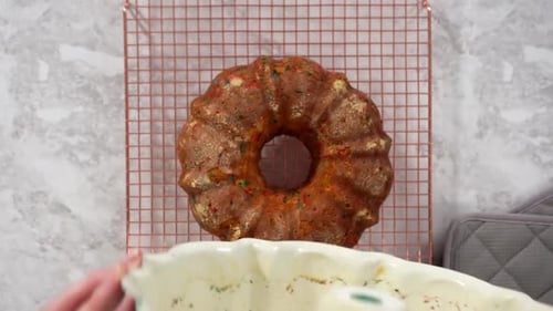 Flach legen und den frisch gebackenen Funfettti-Bundt-Kuchen aus der Bundt-Kuchenform nehmen