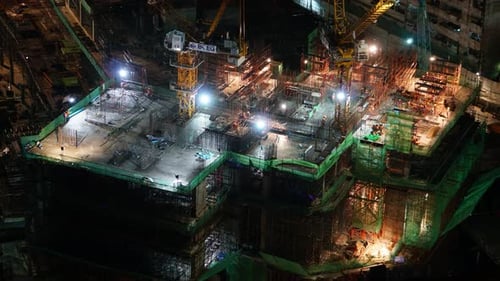 High angle night time-lapse of a building construction site