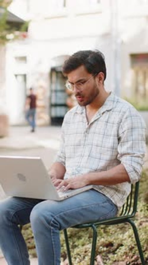 Man Working on Laptop in Urban Outdoor Setting