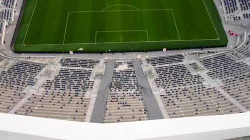 Aerial Tilt up shot revel empty football stadium with City building, drone shot, day light.