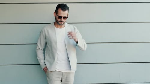 Man in Jacket Poses Against Urban Wall