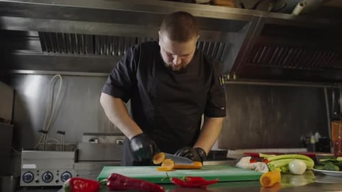 Slow Motion Video of a Chef Cutting Carrots in a Restaurant Kitchen
