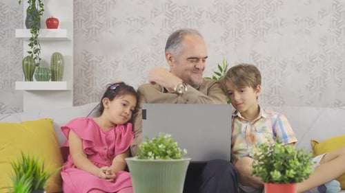 Grandfather and Grandchildren Watching Laptop Together