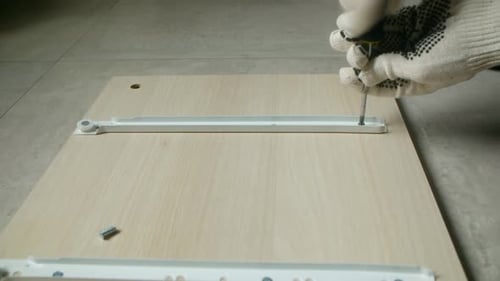 Carpenter Assembling Furniture Using Screwdriver and Screws