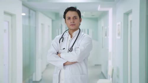 Confident Doctor Standing in Modern Hospital Hallway