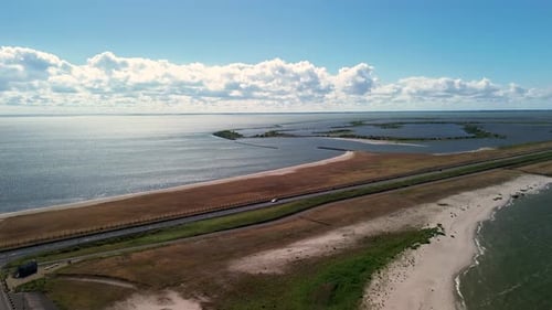 Vue aérienne d'un barrage ou d'une chaussée étroits flanqués de vastes plans d'eau des deux côtés, menant