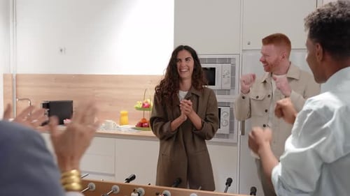 Colleagues Celebrating Victory Playing Foosball in Office Breakroom
