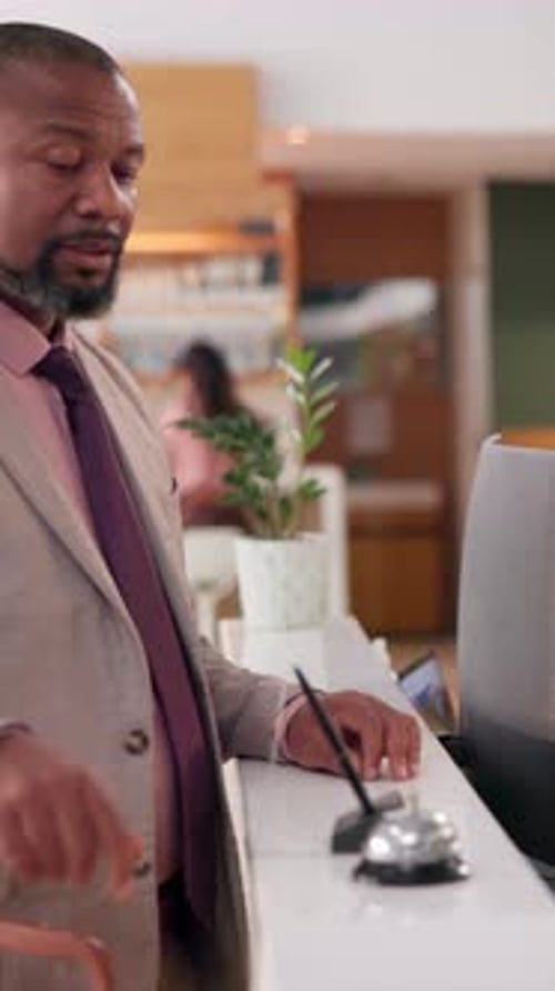 Bell, reception and waiting with black man guest in hotel lobby for check in or reservation