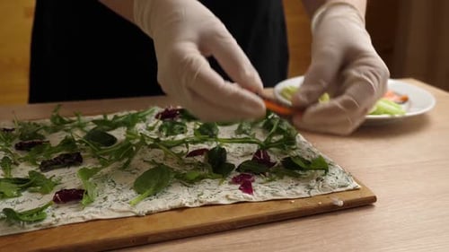 18. Salmon and cucumbers are added to lavash with cheese and greens. Preparation of a roll with chee