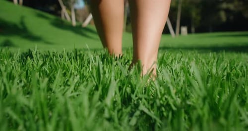 Bare Feet Walk on Green Grass Closeup View