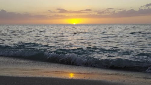 Panoramablick auf die Küste des Atlantischen Ozeans bei Sonnenuntergang Lebendiger oranger und blauer Himmel über ruhigem Wasser