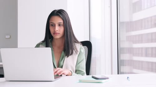 Young Woman Using Laptop Succeeds at Office