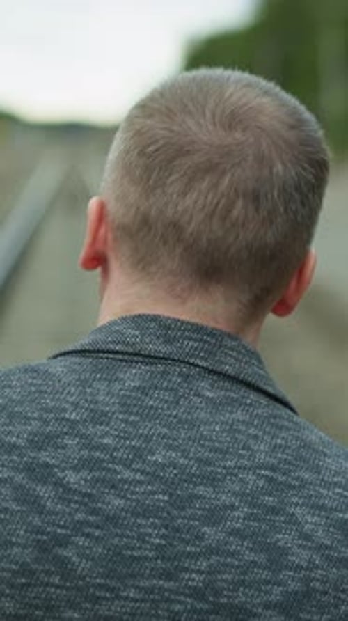 Person Walking Down Rural Railroad Tracks