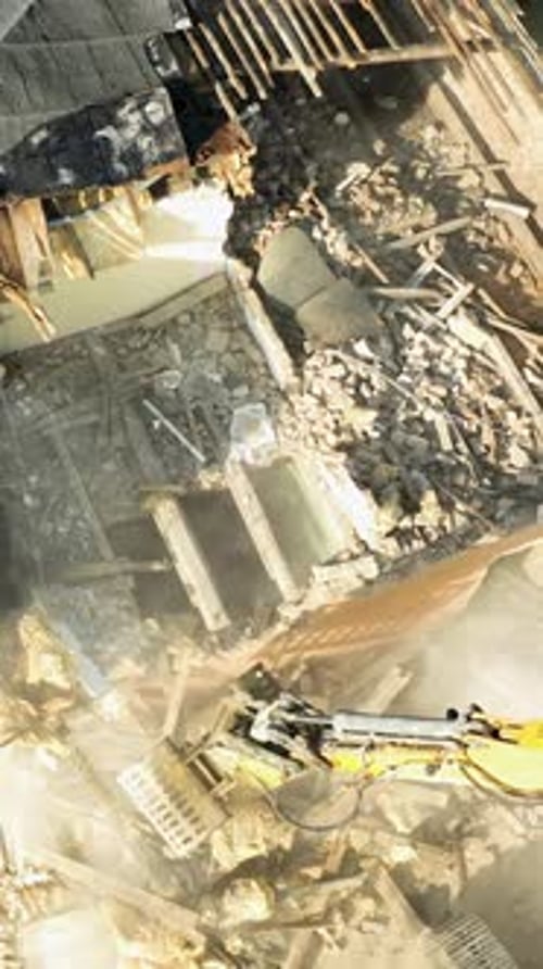 Vista aérea desde arriba de la excavadora que demuele el techo y las paredes de un edificio antiguo