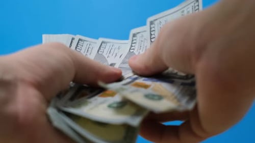 Closeup of Man's Hands Counting Dollar Bills Selective Focus A Stack of Cash American Dollar