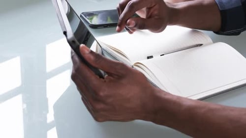 Hands Work With Tablet and Notebook on Table