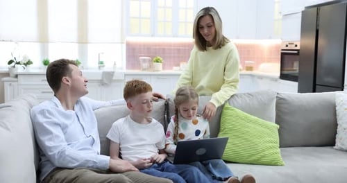 Parents and their kids with laptop at home