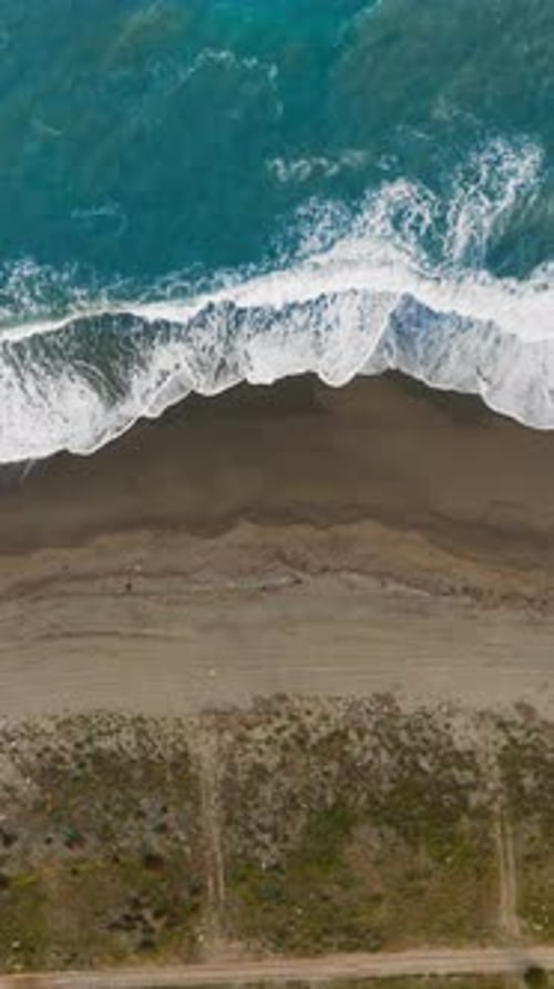 Background With Sandy Beach And Stormy Ocean Waves Crashing On Shore