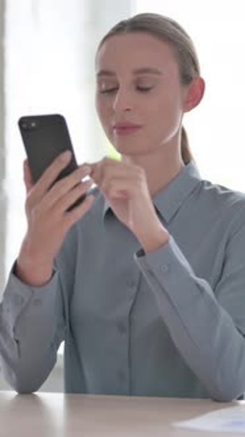 Woman Talking on Phone in Office, Vertical Video