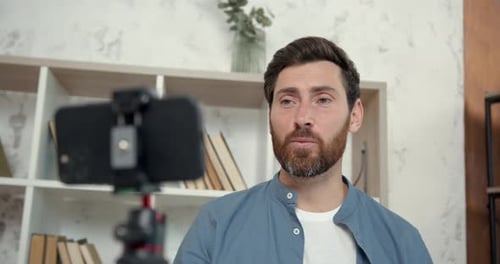 Profesor de inglés masculino grabando un blog de vídeo cerca del escritorio