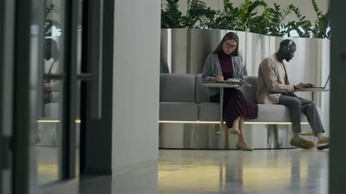 Two Adults Working in Modern Office Booth