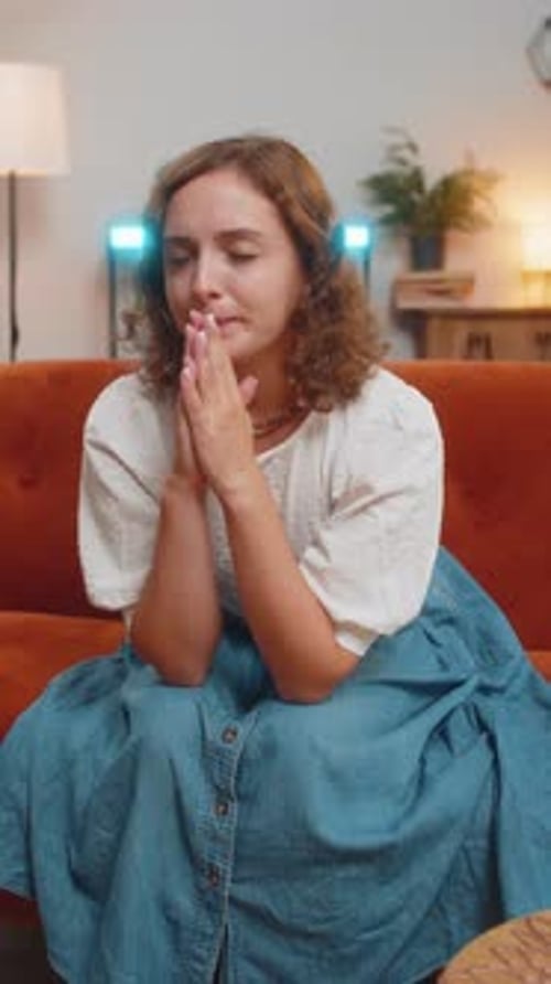Woman Sitting on Couch with Hands Clasped