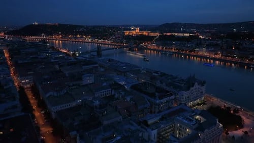 Nachtdolly-Aufnahme von Flusskreuzfahrtschiffen aus der Luft, Schlossberg, Budaer Schloss, Gellértberg