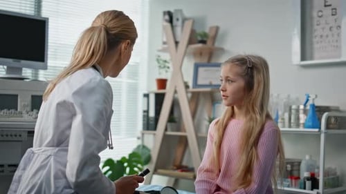 Doctor Speaking with Child Patient in Medical Office