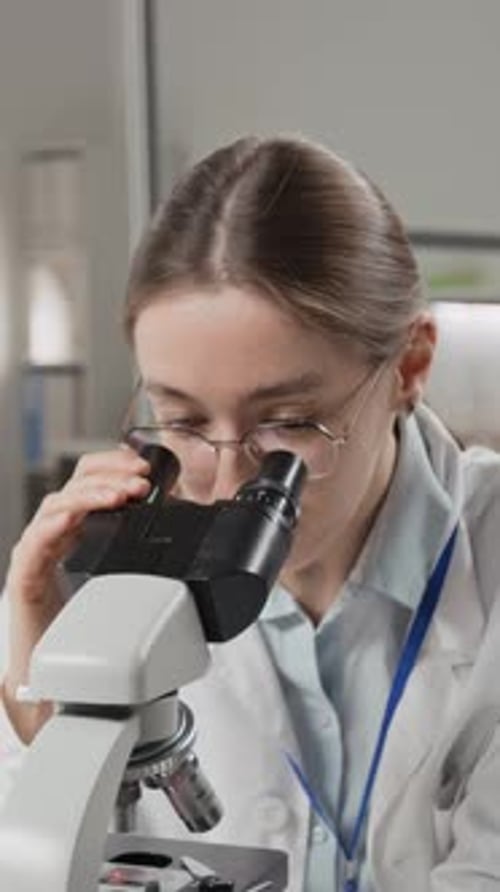 Woman Using Microscope in Laboratory